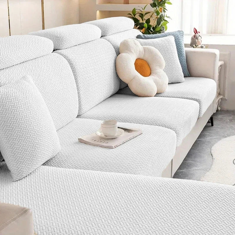 White sectional sofa with decorative pillows and a coffee table in a living room setting.