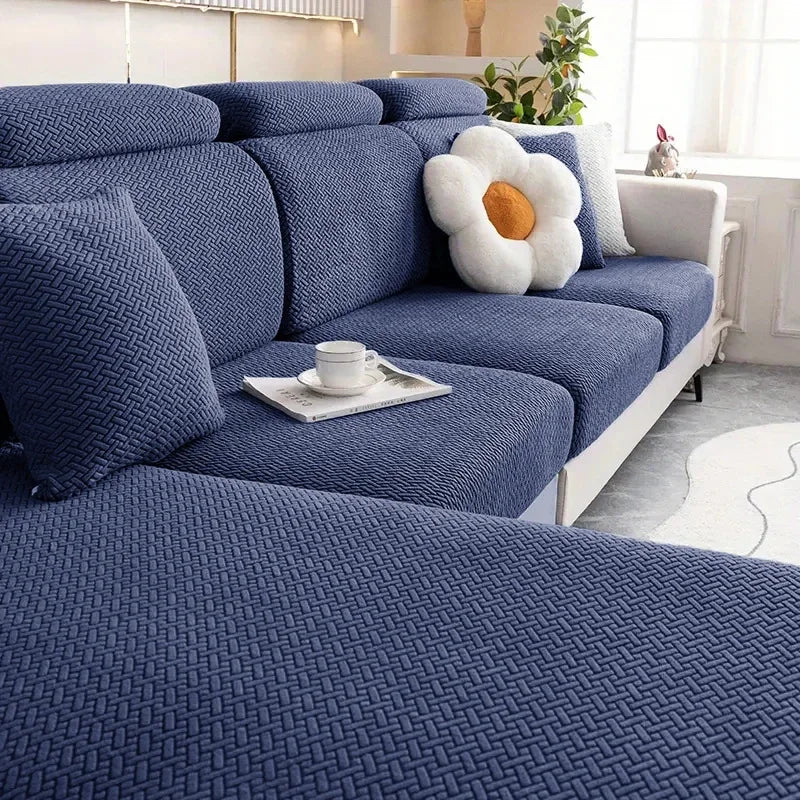 Blue textured sofa with a white flower pillow in a living room setting