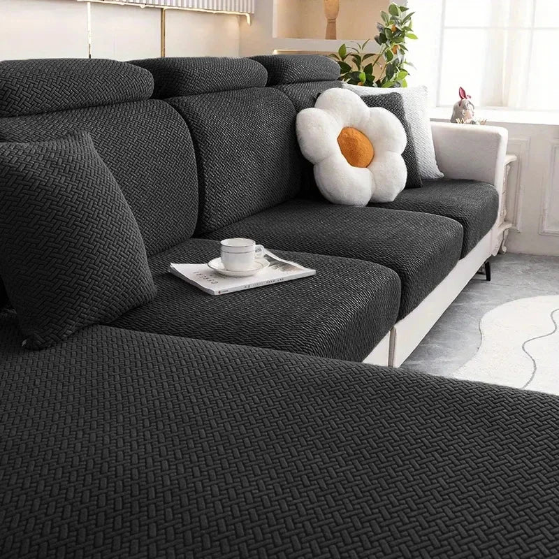 Gray sectional sofa with a flower-shaped pillow in a living room setting.