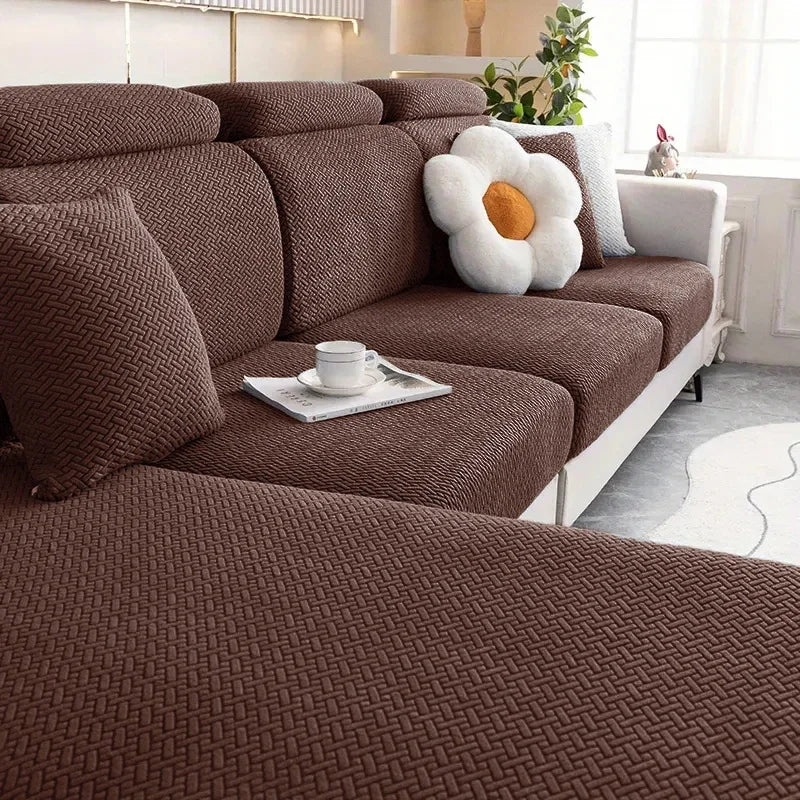 Brown sectional sofa with decorative pillows and a small table in a living room setting.