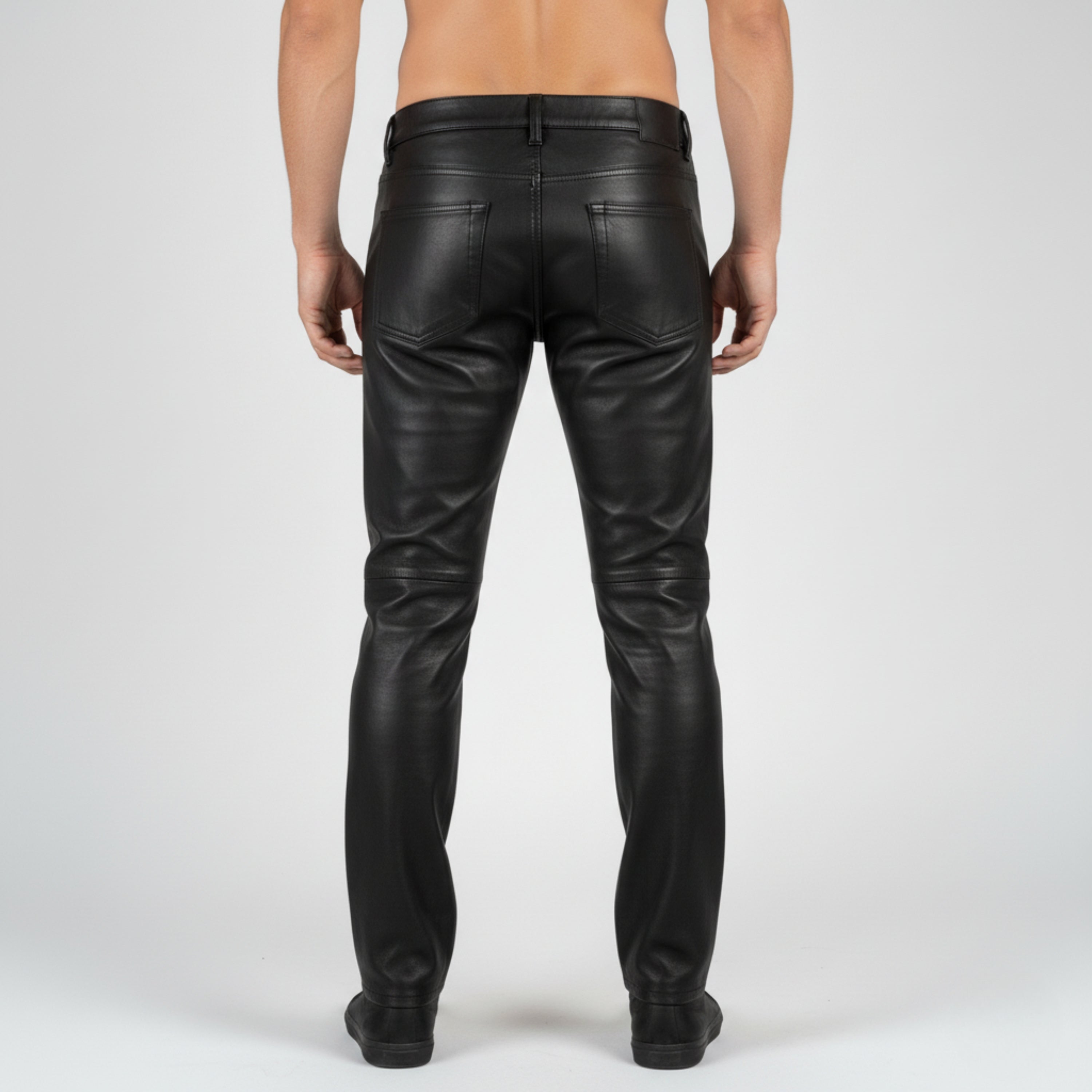 Black leather pants worn by a person on a white background